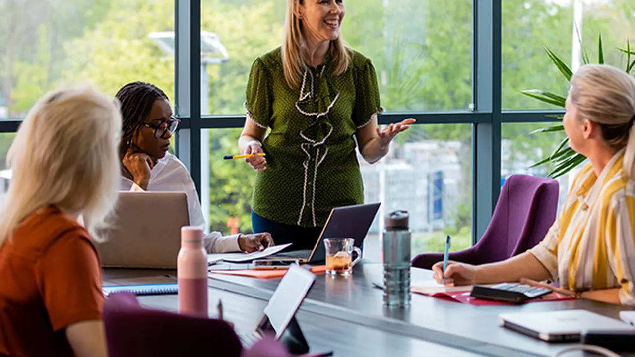 Close up on a plate of mashed potatoes, topped with baked pork chops with cream of mushroom soup, and a side of green beans.